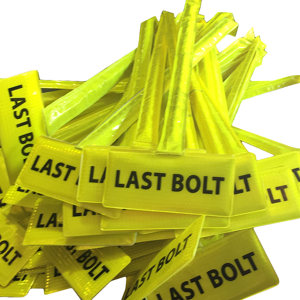 Pile of yellow 'LAST BOLT' labels on a white background