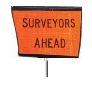 A Reflective Guide Post Roll Up Sign with the text 'SURVEYORS AHEAD' mounted on a post. 