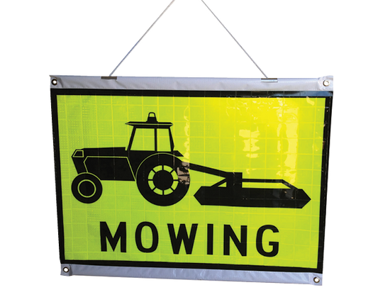 A Rods and Cords Hanging Roll Up Safety sign with a black silhouette of a tractor and the word 'Mowing' printed below it. The sign has top and bottom stiffening rods and is designed for roll-up display.