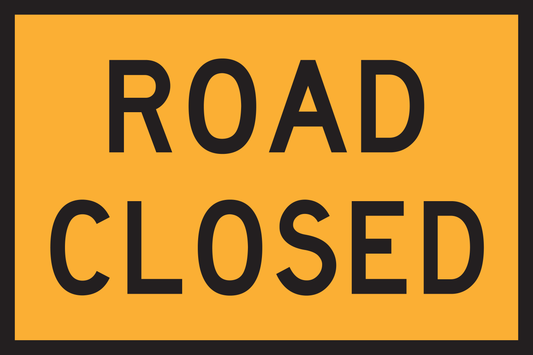 Road closed sign with black text on a yellow background
