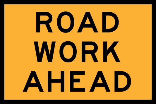 Road work ahead sign with black text on a yellow background